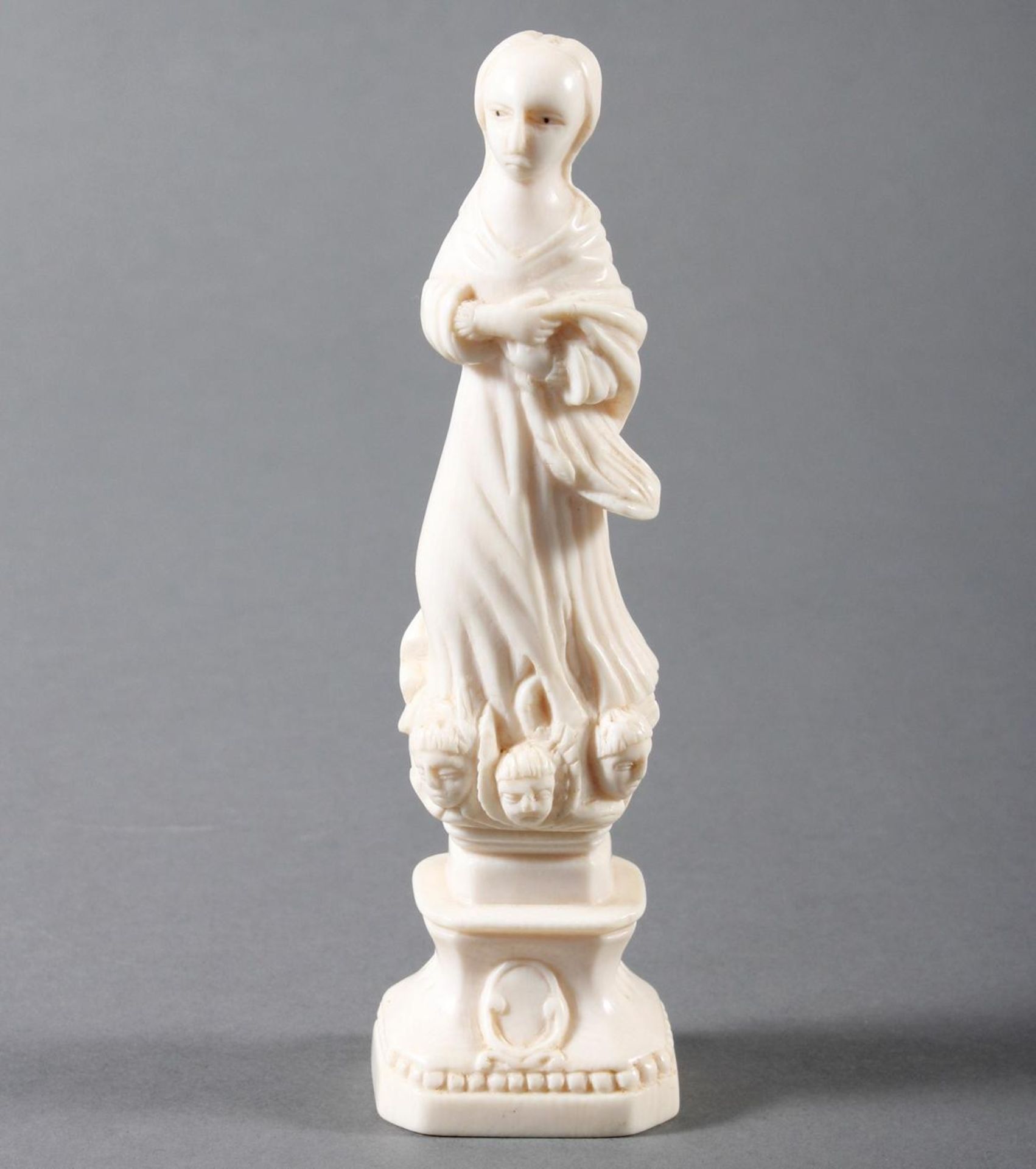 Elfenbeinschnitzerei einer Heiligen auf einem Podest stehend