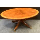 A reproduction oval mahogany quarter veneered occasional table, splayed legs, brass castors, 122cm x