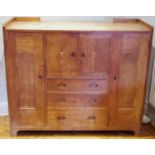 An Arts and crafts side cabinet, in the Heals manner, with two cupboard doors and three drawers,