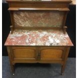 An Arts and Crafts oak washstand, rouge marble splash back and top, two fielded panel doors,