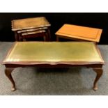 A nest of three graduated shaped rectangular occasional tables; a larger leather inset coffee