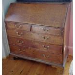 A George III oak bureau, the fall front above two short and three long graduated drawers, the