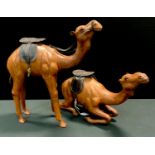 Two leather camels, one standing, 48cm high, another , kneeling 30cm high (2)