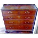 A George III oak chest, of two short and three long graduated cockbeaded long drawers, brass swan