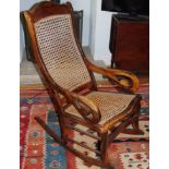 An early 20th century rocking chair, bergere back and seta, scroll arms, c.1870