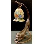 An unusual bronzed metal cat table lamp modelled as a stretching cat with illuminated green eyes