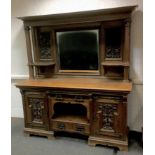 A Victorian Art Nouveau oak sideboard, carved back with central rectangular mirror, shaped side
