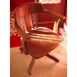 A 20th century oak swivel desk chair, four scroll legs, c.1920