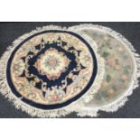 Two Chinese circular throw rugs, floral designs in ecru, taupe and caramel on a blue ground;