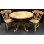 A modern pine drop leaf kitchen table, circular top; two fiddle back kitchen chairs. (3)