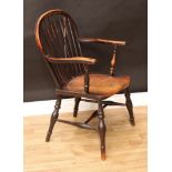 A 19th century elm and ash Windsor elbow chair, arched stick back, serpentine arms, saddle seat,