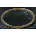 An Arts and Crafts planished copper mounted oval wall mirror, bevelled edge, 82cm x 48cm