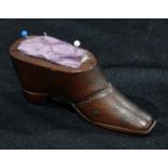 A 19th century mahogany novelty pin cushion, as a shoe, decorated overall with brass pinwork