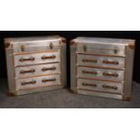 A pair of contemporary chest of drawers as a traveling trunk, hinged top above three long drawers,