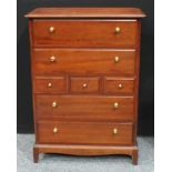 A Stag chest of drawers, oversailing rectangular top above an arrangement of drawers, shaped