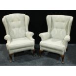 A near pair of early 20th century wing back armchairs