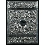 An Indian silver rectangular visiting card case, chased with flowers and scrolling leaves, on a