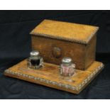 An early 20th century oak combination stationery box and inkstand, in the Jacobean Revival taste,