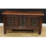 An 18th century oak blanket chest, hinged top enclosing a till, the three panel front carved with