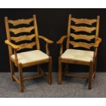 A pair of 20th century oak open armchair/carvers. shaped ladder-backs, slightly outswept arms,