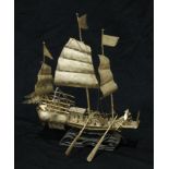 A 19th century silvered model, of a Chinese junk, on hardwood wave base