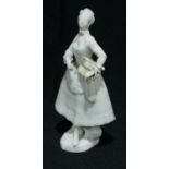 A Vienna figure, in the white, of a lady, holding a basket, 16cm high, Beehive mark
