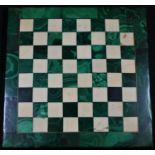 A malachite and marble chess board, outlined throughout with brass stringing, 20cm square