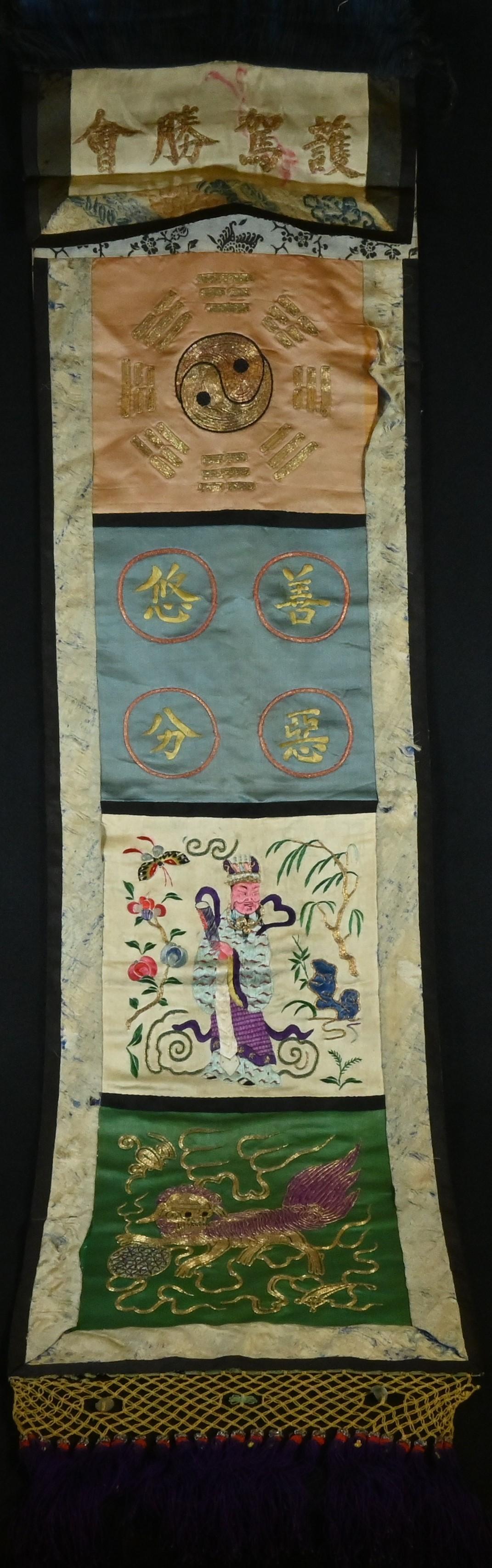 A 19th century Chinese Taoist rectangular silk banner, worked in gilt and coloured threads with a