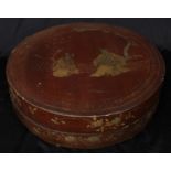 A Chinese lacquer circular box and cover, decorated in gilt with figures before trellis, 31cm