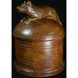 Treen - a folk art cylindrical box, the cover carved with a recumbent dog, 19cm high