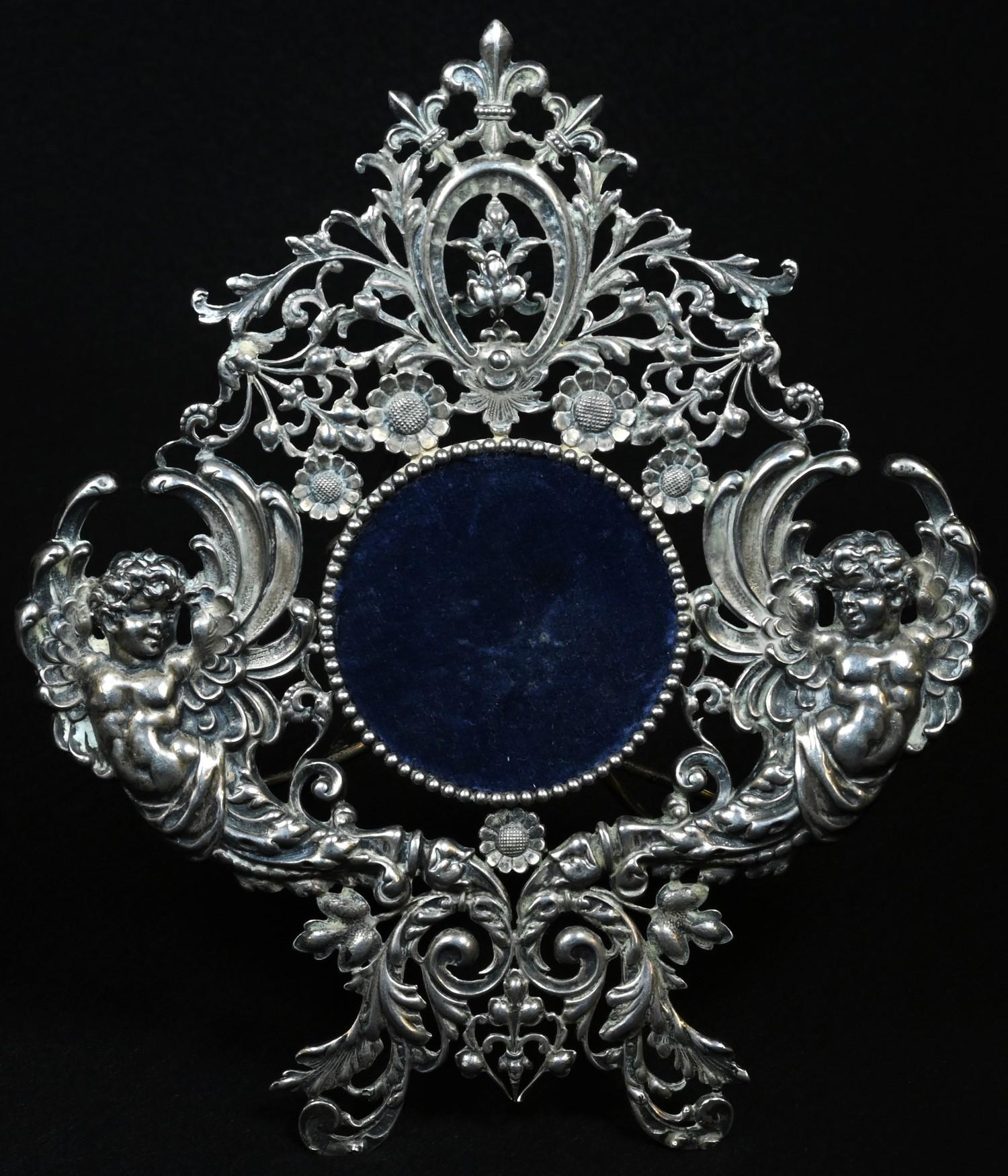 A 19th century Continental silver easel pocket watch stand, pierced and die-stamped with winged