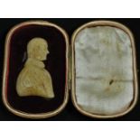 A 19th century wax portrait, of a gentleman, bust length, 5.5cm x 3.5cm, red morocco travelling case