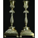 A pair of post-Regency gilt brass candlesticks, half-fluted campana sconces, lotus pillars, fluted