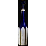 A 19th century Bohemian white overlaid blue glass slender facetted mallet shaped decanter, the lower