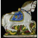 A Middle-Eastern tin-glazed earthenware equestrian model, of a horse, typically decorated in the