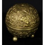 An early 20th century gilt metal globular string box, cast in relief with scrolling leafy strapwork,