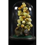 A Chinese hardstone arrangement, carved and formed as a bunch of grapes, 23cm high, glass dome