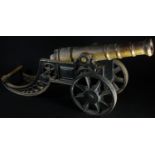 A bronze and cast iron model cannon, the carriage pierced with bands of fuilloche, spoked wheels,