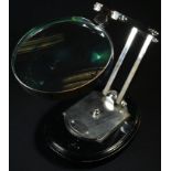 A chrome anglepoise desk top magnifying glass, by Watts & Sons Ltd, London, 12cm lens, the oval