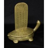 A Chinese bronze desk model, of a turtle supporting a tablet, engraved with dragons and inscribed