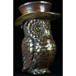 A late 19th century brass novelty vesta case, as an owl wearing a top hat, glass eyes, hinged cover,