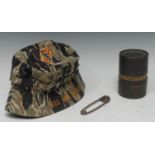 A Vietnam War era Special Forces boonie hat, USMC body bag pin and empty M67 hand grenade tube