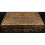 An Indian sandalwood rectangular box, profusely carved with stylised flowers and scrolling leafy