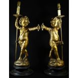A pair of Continental giltwood figural lamps, of scantily clad amorini, each stands, an arrow in one