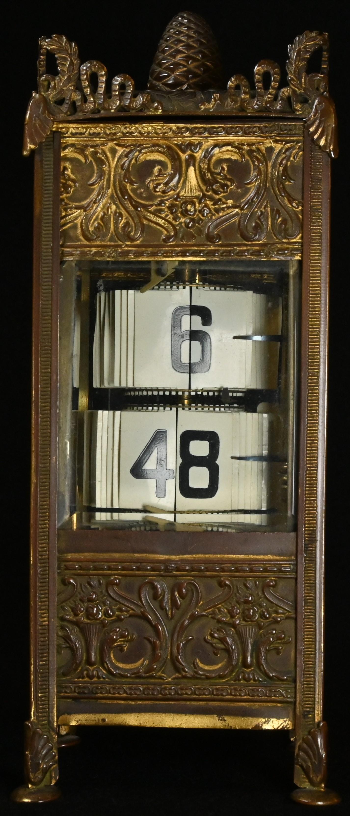 A French gilt metal flip ticket clock, embossed in the Neo-Classical taste with scrolling acanthus