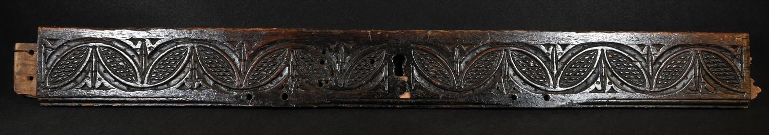 A 17th century oak fragment, carved with a band of leafy lunettes, 88cm long, c.1680