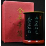 A Chinese lacquer brush pot, inscribed in green with a poem, red seal mark, 11cm high, boxed