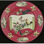 A Chinese famille rose porcelain circular plate, diaper-ended scroll reserve painted in polychrome