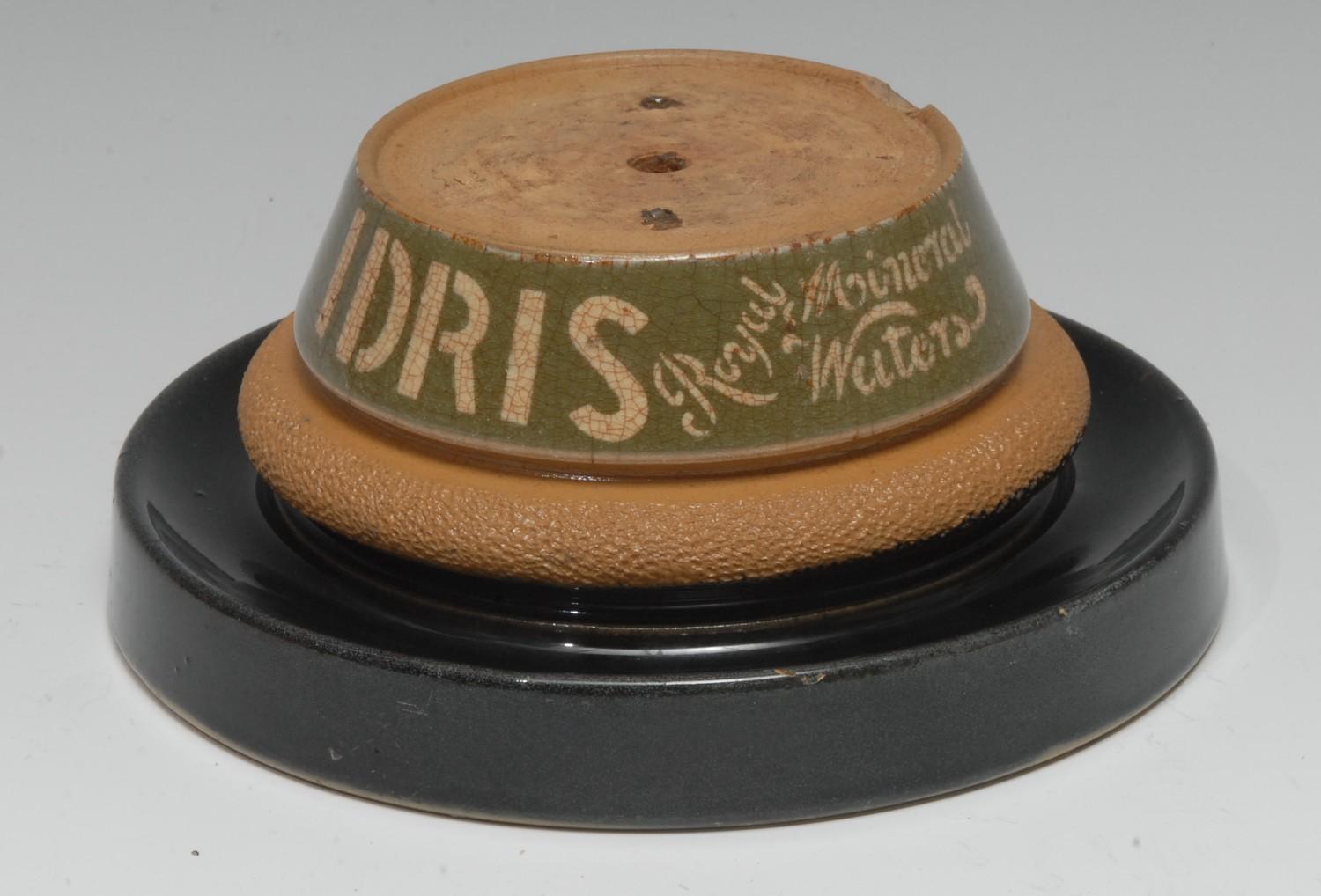 Advertising - a glazed stoneware shop counter top bell stand, Idris Royal Mineral Waters, circular