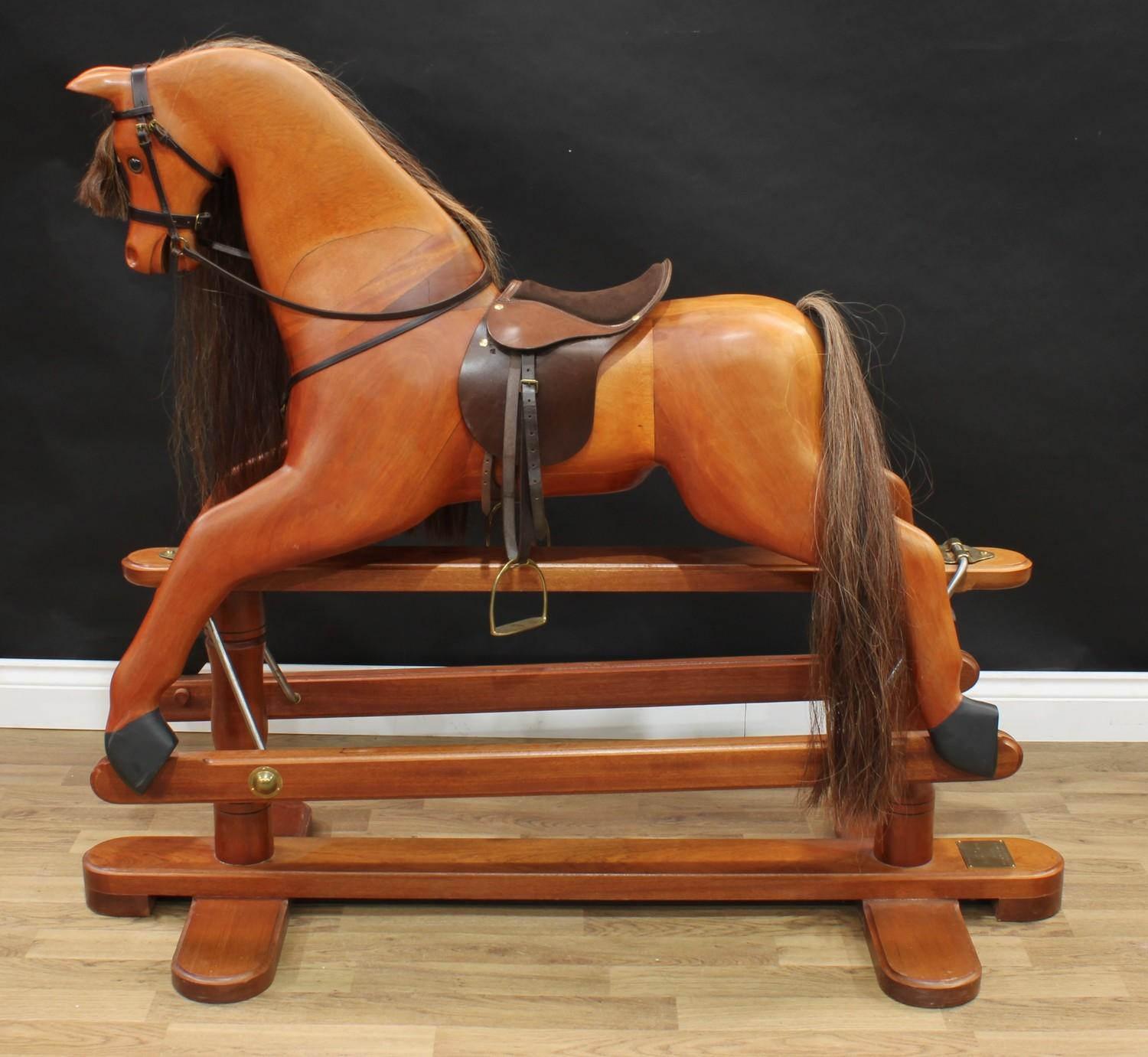 A 20th century House of Marbles (Devon) carved hardwood rocking horse on safety stand, carved